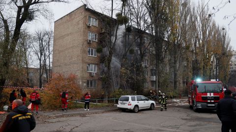Bomberos trabajan en la extinción del fuego producido por el impacto de un misil ruso en un edificio residencial de Kiev.