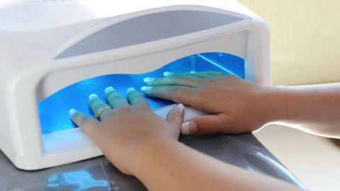 Imagen de archivo de un secador de uas que utiliza luz ultravioleta para fijar el esmalte