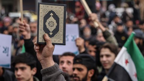 Un manifestante alza un Corán en Idlib (Siria) en una protesta tras la quema de los libros sagrados del islam en Europa.