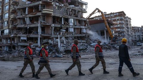 Miembros de la gendarmera turca frente a las ruinas de un edificio en Hatay, Turqua.