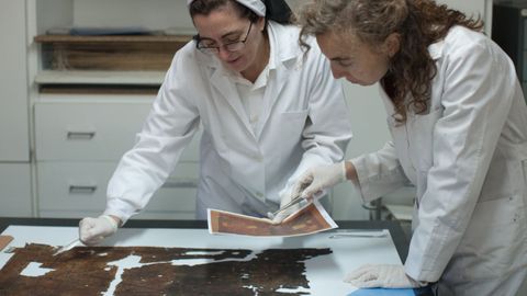 María Dolores Díaz de Miranda analiza junto com una compañera un ejemplar que debe restaurar