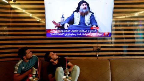 Jóvenes iraquíes atienda al informativo que anunciaba la muerte del primer líder del Estado Islámico, Abu Bakr al Baghdadi, el 27 de octubre del 2019.