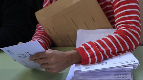 Un miembro de una mesa electoral procede al recuento de votos en un colegio de Madrid.