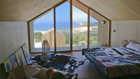 Dormitorio de una de las cabaas del complejo, con impresionantes vistas de la playa de Donios