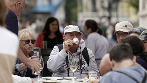 Un turista bebe un café en la plaza de la Catedral, en Oviedo. 