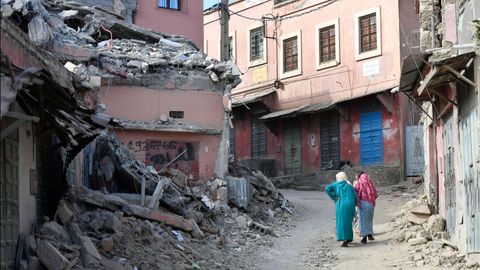 Dos mujeres pasean cerca de un edificio derruido por el terremoto que afect a Marruecos.