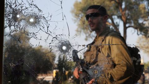 Un soldado israelí, detrás de varios agujeros de bala por los disparos de Hamás.