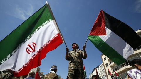 Un militar iran ondea las banderas de su pas y la de Palestina.