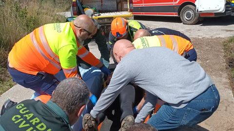 Agentes de la Guardia Civil, bomberos y ambulancia asisten a un ciclista herido en Grado