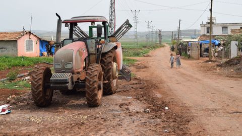 Un tractor y unos nios en el campo de refugiados de Yuneidat, situado en el sur de Turqua prximo a la frontera con Siria.