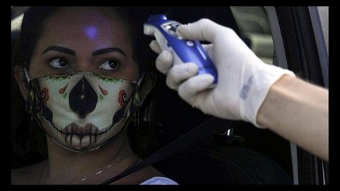 Un sanitario toma la temperatura a una mujer en Brasil