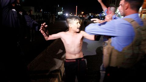 Fuerzas de seguridad iraques detienen a un chico despus de quitarle un chaleco bomba.