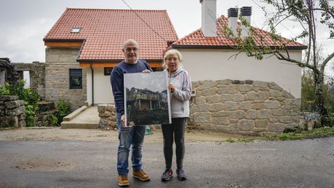 Carmine y Elvira posan con una fotografa de su antigua vivienda