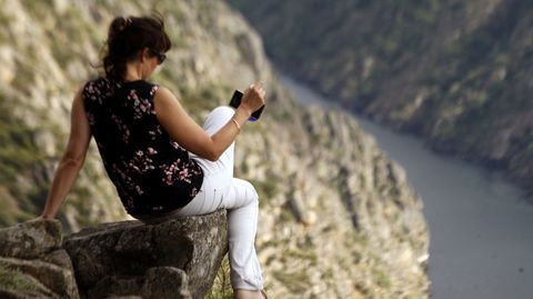 Una mujer saca una foto del cañón del Sil en las cercanías del mirador de Santiorxo, en Sober