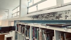 La pared de la biblioteca del CEIP Plurilinge Santa Rita de Galdo, en Viveiro, llena de humedades.