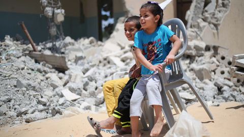 Dos nios sentados ante las ruinas de sus casas en Gaza. 