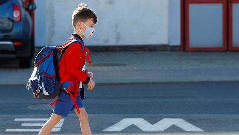 Un nio, con una mascarilla, llega al colegio en Austria