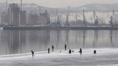 Un grupo de gente pesca en el lago Yenisei, congelado