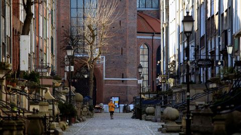 Una mujer camina en soledad por una calle de Gdansk, en Polonia