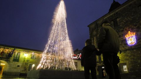 Un niño mira el árbol de Navidad situado la localidad de Melide el pasado año