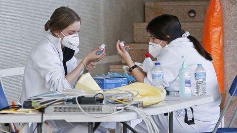 Dos trabajadoras sanitarias preparan dosis de AstraZeneca para su administracin en el Pazo de Congresos de Pontevedra