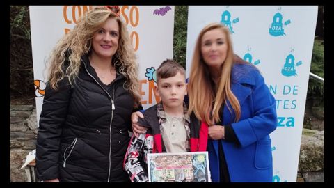 Stanilav Ribitva, un niño ucraniano de 10años acogido por Cruz Roja en A Coruña (en el centro), ganador del primer premio del Concurso de Dibujo de Halloween organizado por la Asociación de Comerciantes Distrito Oza de A Coruña