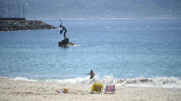 El sol deslumbra en Sanxenxo sobre una playa de Silgar de agua clara y con las terrazas llenas