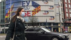 Una mujer pasa por la sede del club comunitario decorada con banderas de Macedonia del Norte y de la UE en Skopje