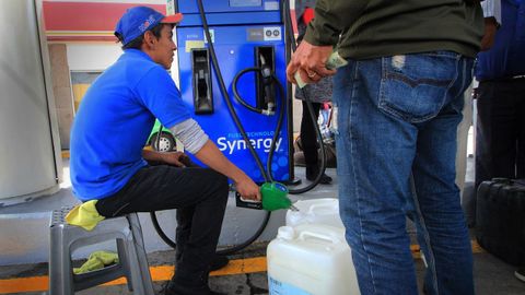 Un empleado de una gasolinera despacha combustible racionado en Mxico