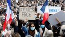 Una joven muestra la pancarta de recuerdo del profesor degollado este domingo en la plaza de la República de París
