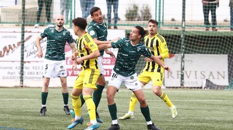 Mario Sesé, con Masca al fondo, disputa un balón durante el Guijuelo-Vetusta
