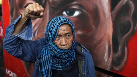Manifestantes filipinos sostienen pancartas duratne una marcha en Manila