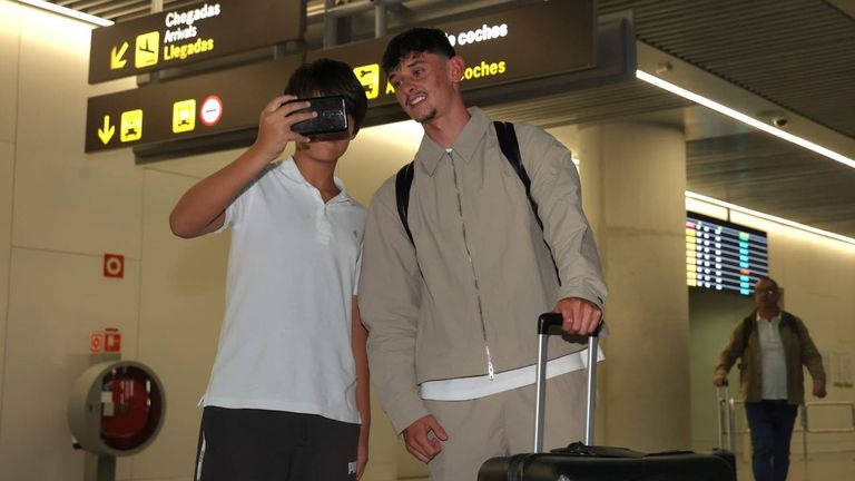 Charlie Patiño posa para un aficionado del Deportivo tras su llegada a Lavacolla