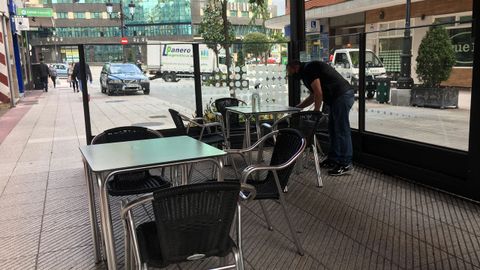 Un hostelero desinfecta una de las mesas de su terraza, en Oviedo