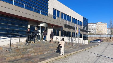 Varios ciudadanos aguardan a la puertas de la sede de Hacienda en Ferrol.