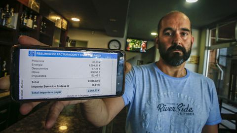 Sergio Fernández, del Bahía de Ribeira, muestra una factura de la luz que dice, se ha duplicado.
