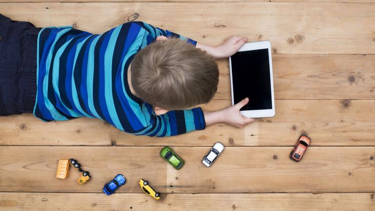 Un niño juego con una tablet, en una imagen de archivo