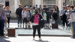 Un grupo de turistas atendiendo una explicación de una guía en la piscina romana de Santa María