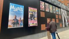 Una pareja de hombres observa las pelculas de estreno del nuevo cine de Oviedo