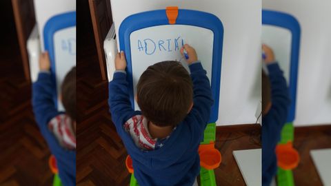 Adrián, que empezó este año el colegio, repasa letras y números en su pizarra