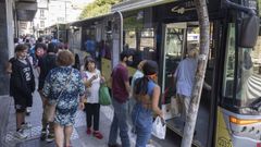 Viajeros se suben a un bus urbano, este lunes, en la parada de la praza de Galicia. 