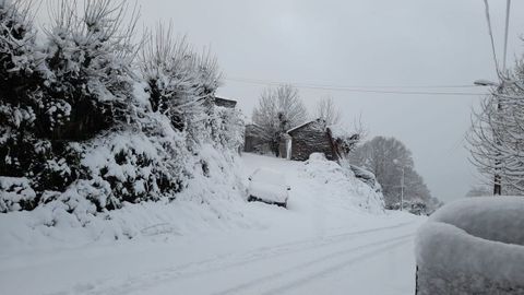 Un aspecto del vial de acceso a la localidad de Meiraos, donde la nieve ha alcanzado esta mañana una altura de cerca de veinte centímetros