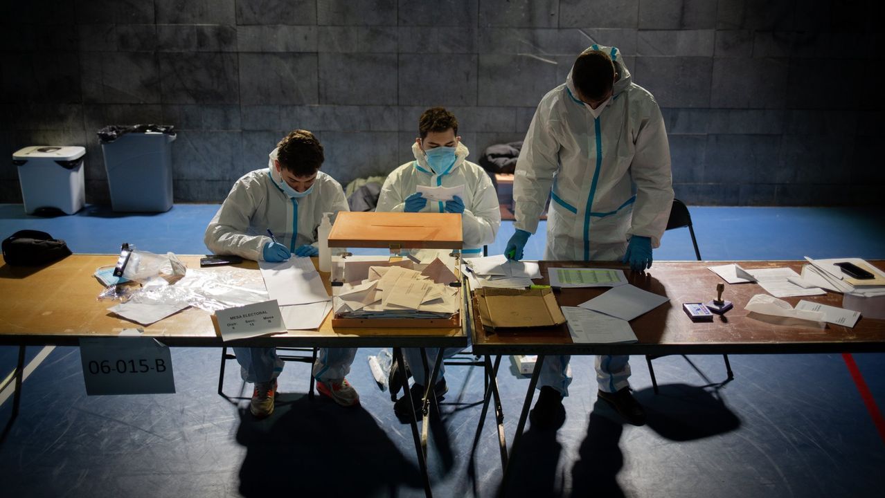 Miembros de una mesa electoral en Cataluña inician el recuento de los votos todavía ataviados con equipos de protección