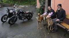 Jane y Eric, ayer ante la puerta de su casa en Manselle (Dodro) junto a sus galgos y sus dos motos