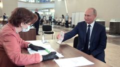 El presidente ruso, Vladimir Putin, ensea su pasaporte antes de votar, este mircoles en el referendo sobre la reforma constitucional