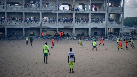 Un equipo de ftbol somal juega junto a una escuela abandonada y destruida en Mogadiscio