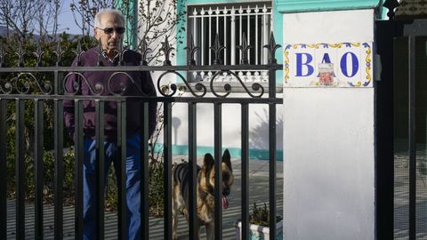 Domingo González, junto a su perra Teta, en la casa que construyó junto al embalse