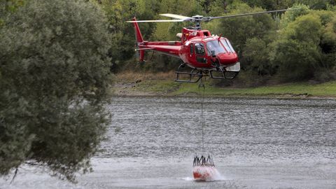 Un helicptero carga en el ro Sil para llevar agua al incendio de Ribas de Sil.