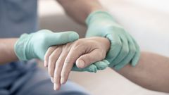 Imagen de archivo de una anestesista sosteniendo la mano de un paciente