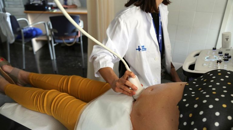 Una sanitaria de Barcelona le hace una ecografía a una embarazada que se va a vacunar